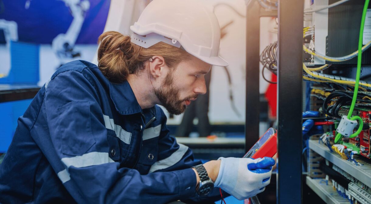 Un électricien faisant la maintenance électrique préventive d’une habitation.