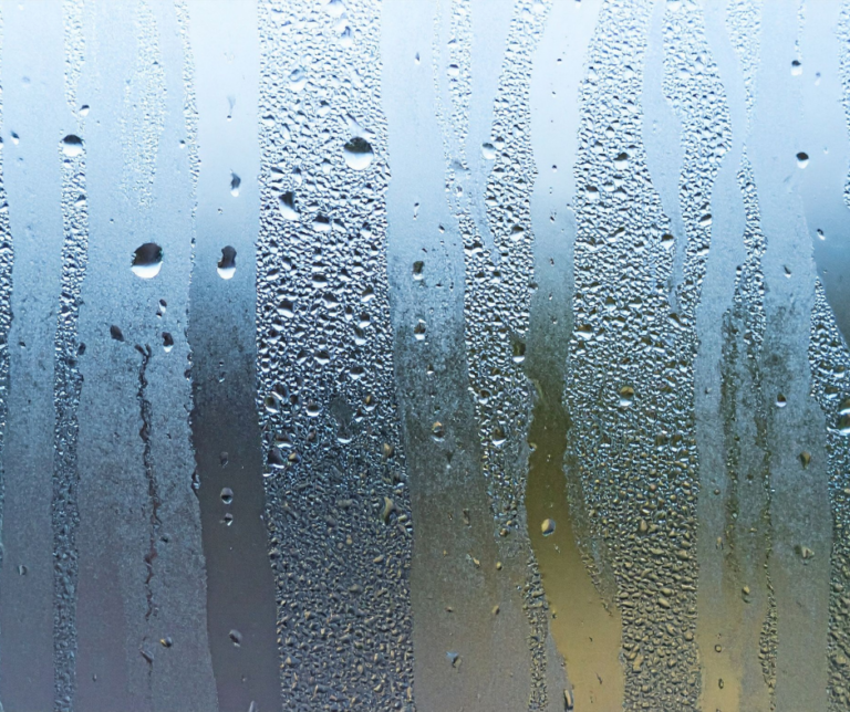 Moisissure sur un mur près d'une fenêtre la nuit.